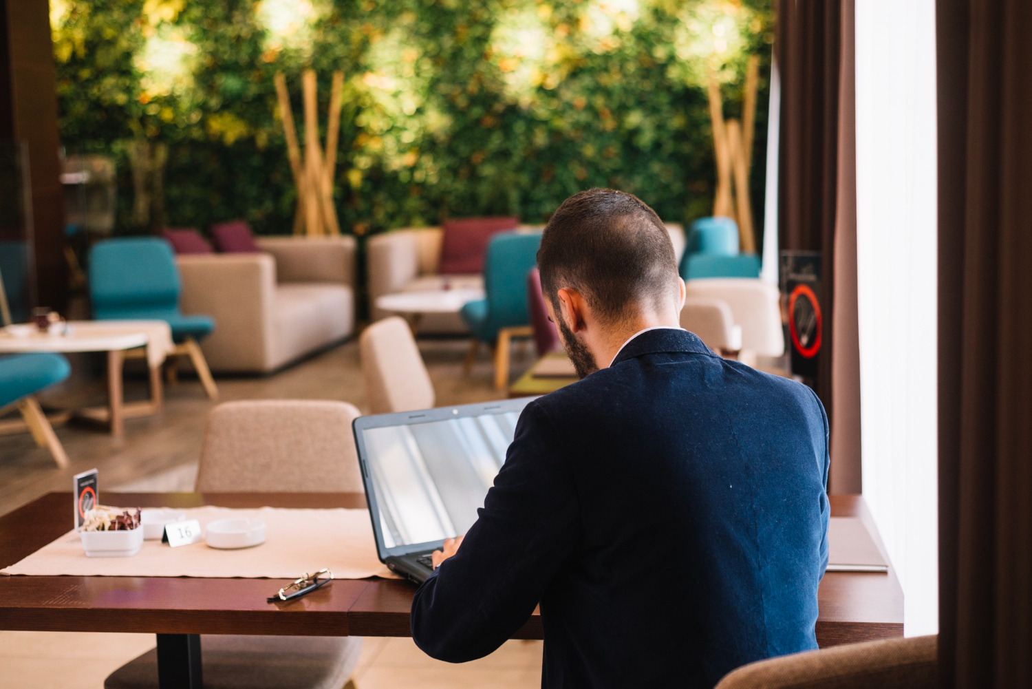 Journaliste de dos avec ordinateur dans un café